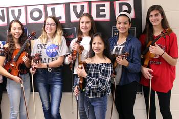 six girls hold violins