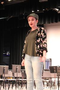 a girl stands on a stage speaking