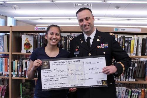 a girl and man hold a large check
