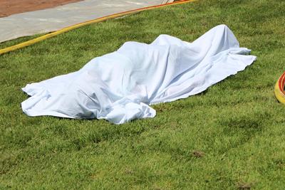 a body lies on the ground covered with a sheet